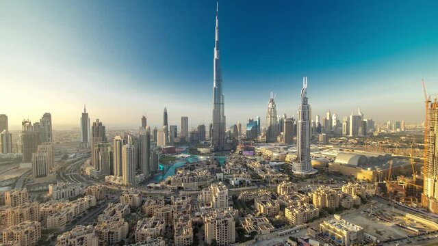 Dubai Downtown evening timelapse with Burj Khalifa and other towers paniramic view from the top in Dubai, United Arab Emirates. Shadows moves very fast. Traffic on circle road and fountains