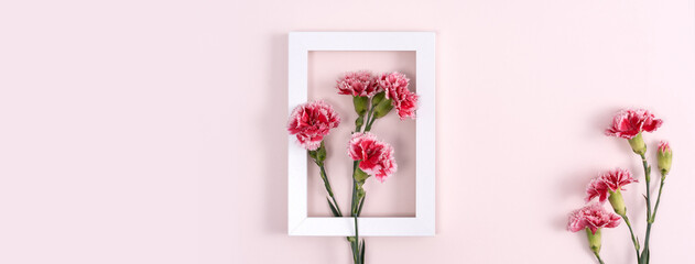 Concept of Mother's day holiday greeting with carnations bouquet on pink background