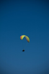 people paragliding, alone with blue sky background without any cloud
