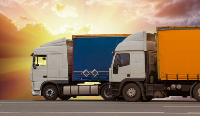 Trucks move along the highway against the red sunset sky