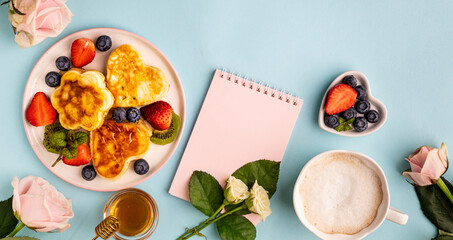 Valentine's day flat lay with heart shaped pancakes on a blue background. Valentine's Day concept. View from above. Banner