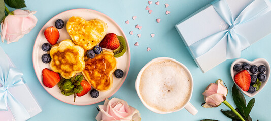 Valentine's day flat lay with heart shaped pancakes on a blue background. Valentine's Day concept. View from above. Banner