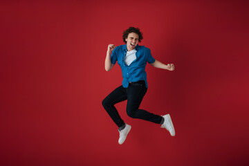 Fototapeta na wymiar Excited handsome young man making fun while jumping