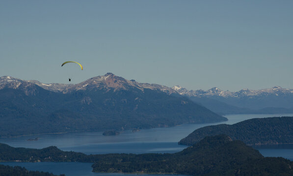 parapente de paracaidas amarillo sobre la ciudad y las afueras de bariloche