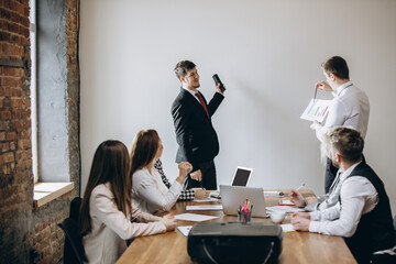 Question. Male speaker giving presentation in hall at university workshop. Audience or conference hall. Participants, co-workers listening at the table. Scientific, business event, training. Education
