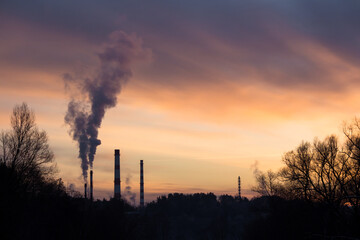 Colorful sunset on the background of smoking pipes