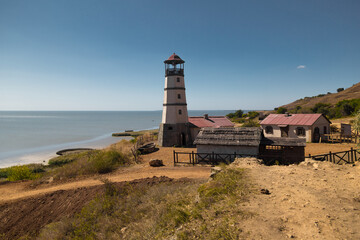 Fototapeta na wymiar Lighthouse at the beach at the sea