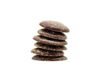 A Pile of Dark Chocolate Buttons against a White Background