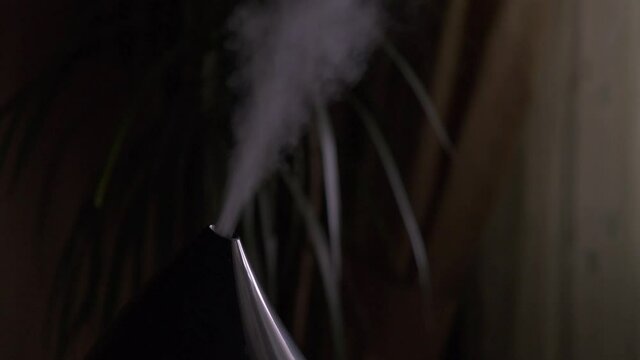 Steam from a modern air humidifier in dark room. Close-up, no people.
