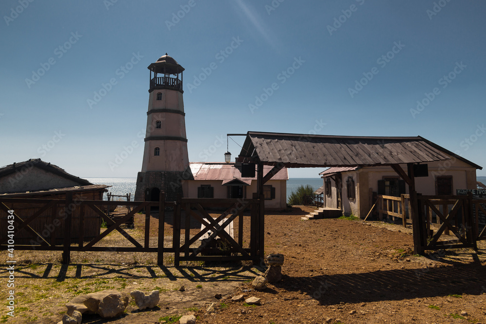 Wall mural lighthouse at the beach at the sea