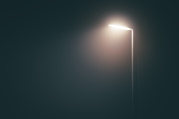 Streetlight post with bright light in a misty fog