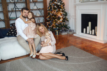 Portrait of a smiling family at Christmas time holding lots of presents at home