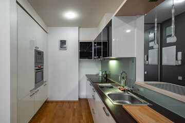 Contemporary interior of kitchen in luxury flat. Modern kitchen set with sink.