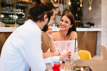 Young happy couple at a date in a coffee shop