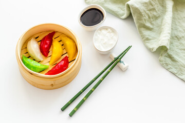 Colored dumplings in wooden steamer, top view