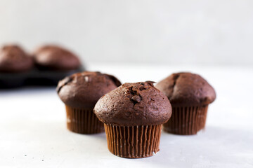 Homemade chocolate muffins or cake on a light table. Homemade or bakery pastries for breakfast or celebration