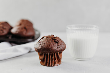 Homemade chocolate muffins or cake with a glass of milk. Place for text. Homemade or bakery pastries for breakfast or celebration