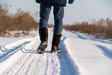 Fototapeta na wymiar Man walking on a snowy road.