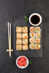 Sushi rolls set of two types with pickled ginger, soy sauce and chopsticks.