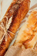 Top view of two baguette bread on a textile surface.  Concept of homemade bread, small bakery, natural farm products, local food,  domestic production. Healthy and tasty organic food. Copy space.
