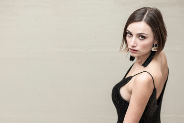 Bellissima ragazza con i capelli a caschetto e un abito nero corto con bretelle  isolata su sfondo...