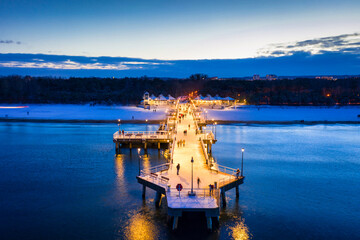 Illuminated pier in Brzezno on the winter beach at dusk, Gdansk.  Poland. © Patryk Kosmider