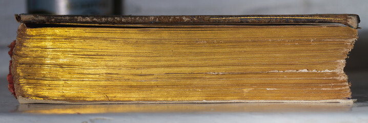 Texture of the golden pages of an ancient book, side view
