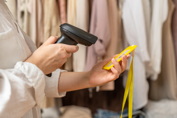 A warehouse woman scanning id cards of employee using barcode scanner in female clothing store