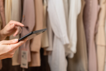 Female entrepreneur holding tablet while doing inventory in her trendy clothing shop