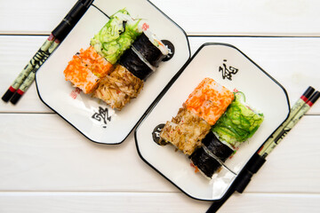 Several sushi on a white plate standing on a white background
