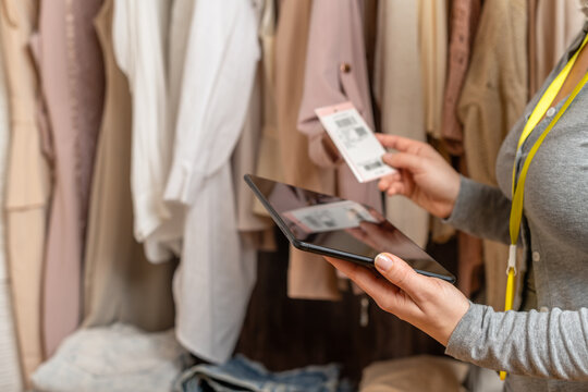 Female entrepreneur holding tablet while doing inventory in her trendy clothing shop