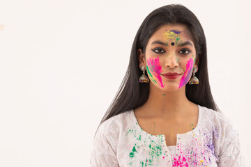 PORTRAIT OF A YOUNG WOMAN WITH HOLI COLOURS ON HER FACE	