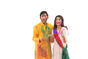 A YOUNG MAN AND WOMAN WITH GULAL HAPPILY WISHING HOLI	