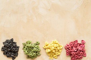 Heaps of pasta - various colors farfalle pasta, top view