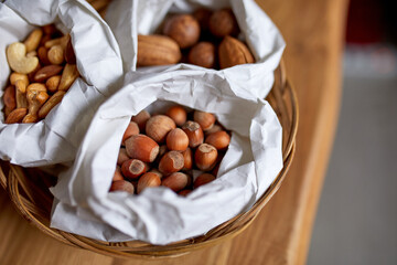 Top view Various sort of nuts on the table in a paper bag on wooden background