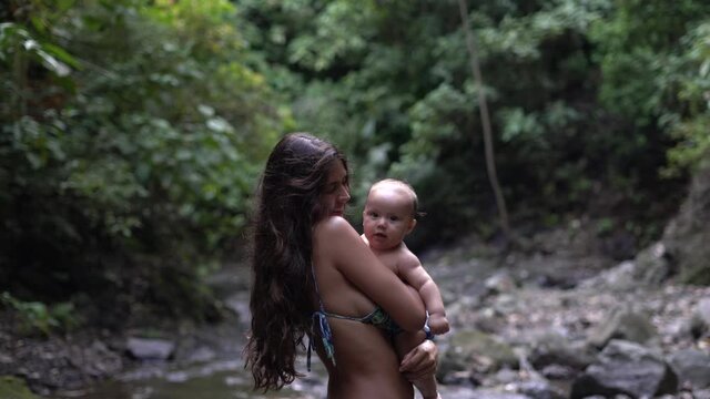 Woman playing with her baby son in a natural setting in Costa Rica