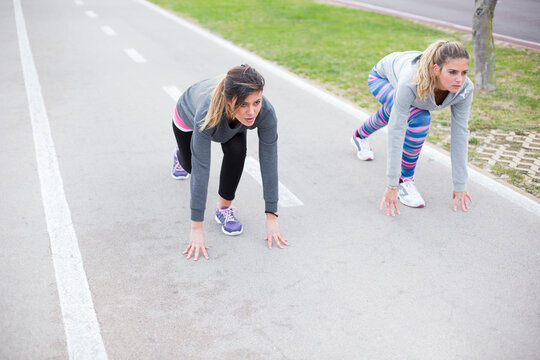 amiche in abbigliamento sportivo sono pronte a fare una gara in una pista da corsa