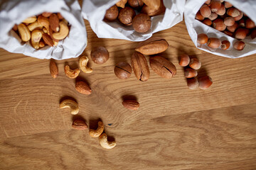 Top view Various sort of nuts on the table in a paper bag on wooden background