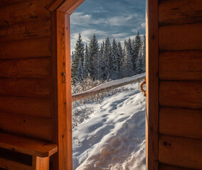 View from  wooden house with plunge font pool for ablutions at the holy spring in a natural park in sunny winter day.