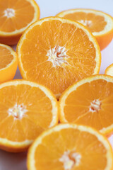 The orange halves are on the table. On a gray and white background.