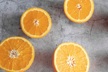 The orange halves are on the table. On a gray and white background.