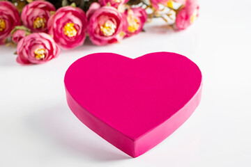 Obraz premium Pink heart for valentines day on a background of flowers.