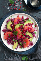 Red cabbage salad with avocado, grapefruit and pomegranate. Diet food. Top view with copy space.