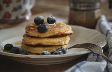 Delicious homemade cheesecakes drizzled with honey and sprinkled with fresh blueberries, on a wooden background