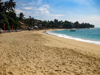 Unawatuna, Sri Lanka - December 9. 2011: View on tropical beach lagoon with waves and palm trees
