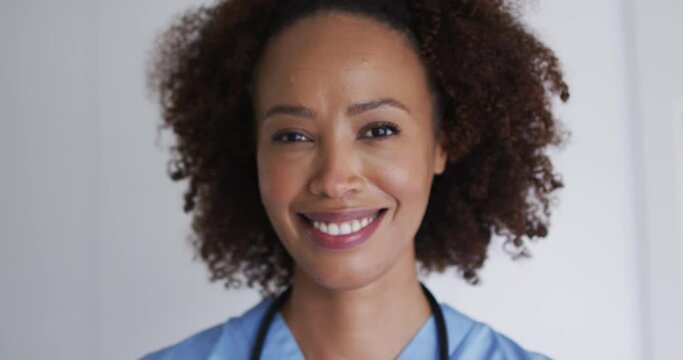 Portrait of mixed race female doctor looking at camera and smiling