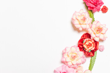 Frame made of rose flowers on white background. Top view with copy space.