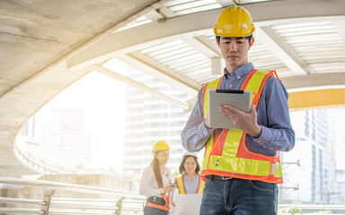 Asian engineer using tablet for planning construction project