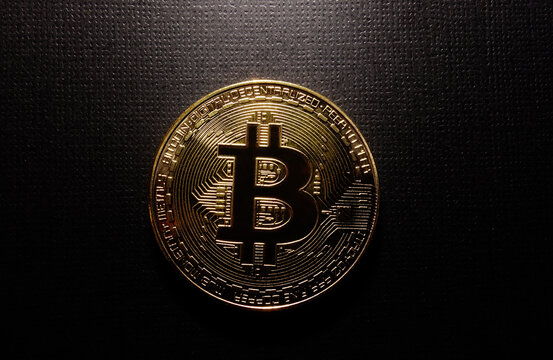 Gold bitcoin on dark textured background