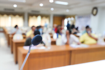 Front of Microphone with blurred many people background on the hall. Microphone on stage. activity indoor concept. seminar or meeting concept.